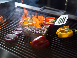 Image showing chef cooking steak with vegetables on a barbecue