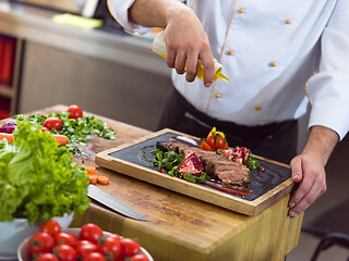 Image showing Chef finishing steak meat plate