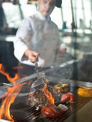 Image showing chef cooking steak with vegetables on a barbecue