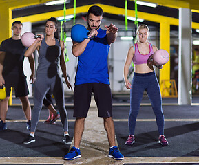 Image showing athletes doing exercises with kettlebells