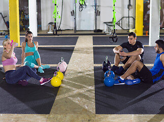 Image showing young athletes sitting on the floor and relaxing