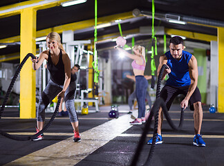 Image showing sports couple doing battle ropes crossfitness exercise