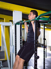 Image showing man doing pull ups on the horizontal bar