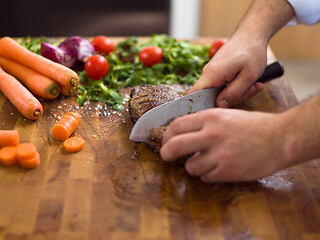 Image showing closeup of Chef hands preparing beef steak