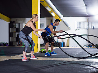 Image showing sports couple doing battle ropes crossfitness exercise