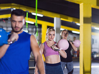 Image showing athletes doing exercises with kettlebells