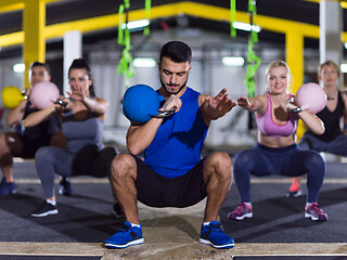 Image showing athletes doing exercises with kettlebells