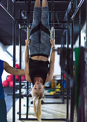 Image showing woman working out with personal trainer on gymnastic rings