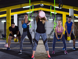 Image showing athletes doing exercises with kettlebells