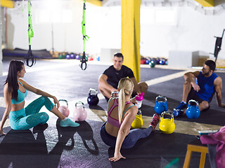 Image showing young athletes sitting on the floor and relaxing