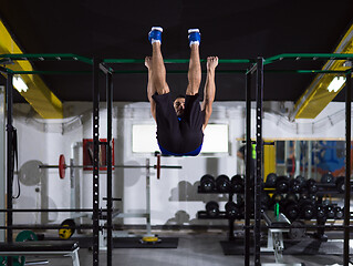 Image showing man doing pull ups on the horizontal bar