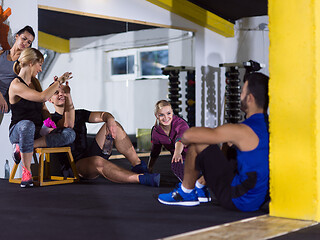 Image showing young athletes sitting on the floor and relaxing