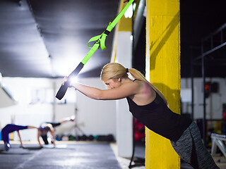 Image showing woman working out pull ups with gymnastic rings