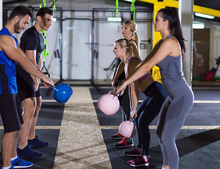 Image showing athletes doing exercises with kettlebells