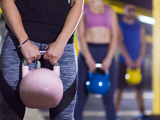 Image showing athletes doing exercises with kettlebells