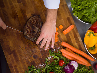 Image showing closeup of Chef hands preparing beef steak