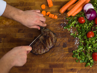 Image showing closeup of Chef hands preparing beef steak