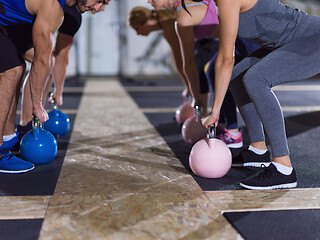 Image showing athletes doing exercises with kettlebells