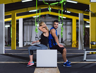 Image showing portrait of athletes working out  jumping on fit box