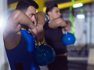 Image showing athletes doing exercises with kettlebells