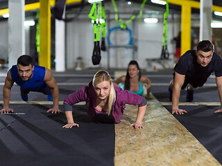 Image showing young healthy people doing pushups