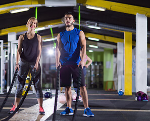 Image showing sports couple doing battle ropes crossfitness exercise