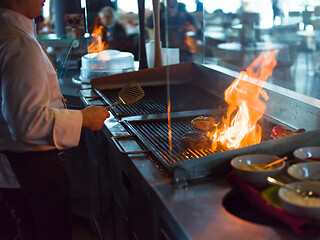 Image showing chef cooking steak with vegetables on a barbecue