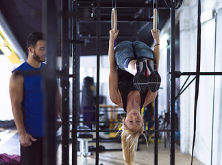 Image showing woman working out with personal trainer on gymnastic rings