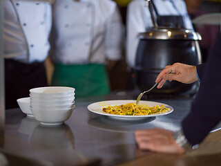 Image showing chefs in the kitchen presenting dish of tasty meal