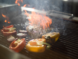 Image showing chef cooking steak with vegetables on a barbecue