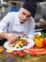 Image showing cook chef decorating garnishing prepared meal