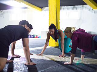 Image showing young healthy people doing pushups