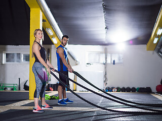 Image showing sports couple doing battle ropes crossfitness exercise