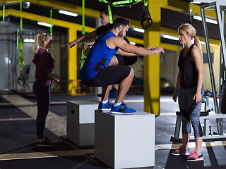 Image showing athletes working out  jumping on fit box