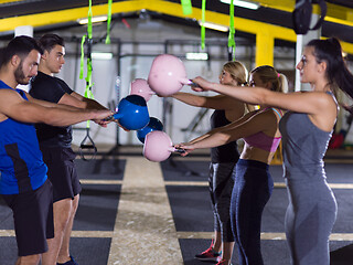 Image showing athletes doing exercises with kettlebells