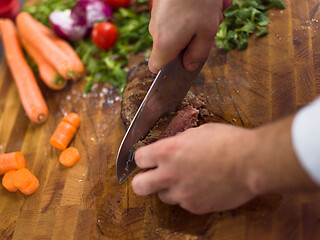 Image showing closeup of Chef hands preparing beef steak