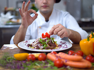 Image showing cook chef decorating garnishing prepared meal