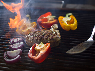 Image showing chef cooking steak with vegetables on a barbecue