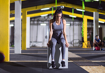 Image showing woman warming up and stretching on fit box