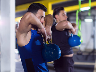 Image showing athletes doing exercises with kettlebells