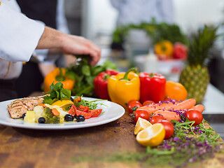 Image showing cook chef decorating garnishing prepared meal