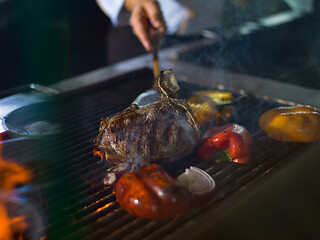 Image showing chef cooking steak with vegetables on a barbecue