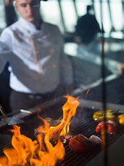 Image showing chef cooking steak with vegetables on a barbecue