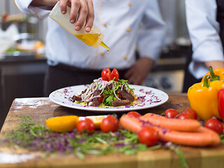 Image showing Chef finishing steak meat plate