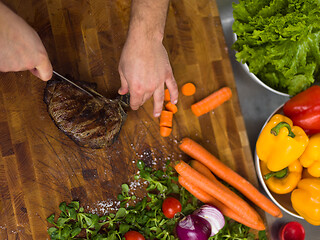 Image showing closeup of Chef hands preparing beef steak