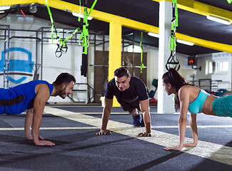 Image showing young healthy people doing pushups