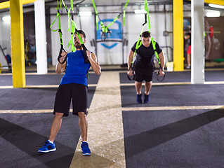 Image showing men working out pull ups with gymnastic rings