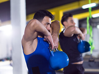 Image showing athletes doing exercises with kettlebells