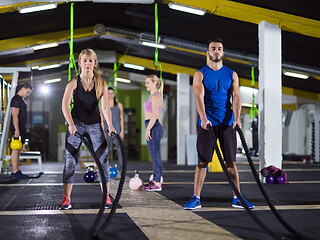 Image showing sports couple doing battle ropes crossfitness exercise