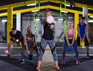 Image showing athletes doing exercises with kettlebells